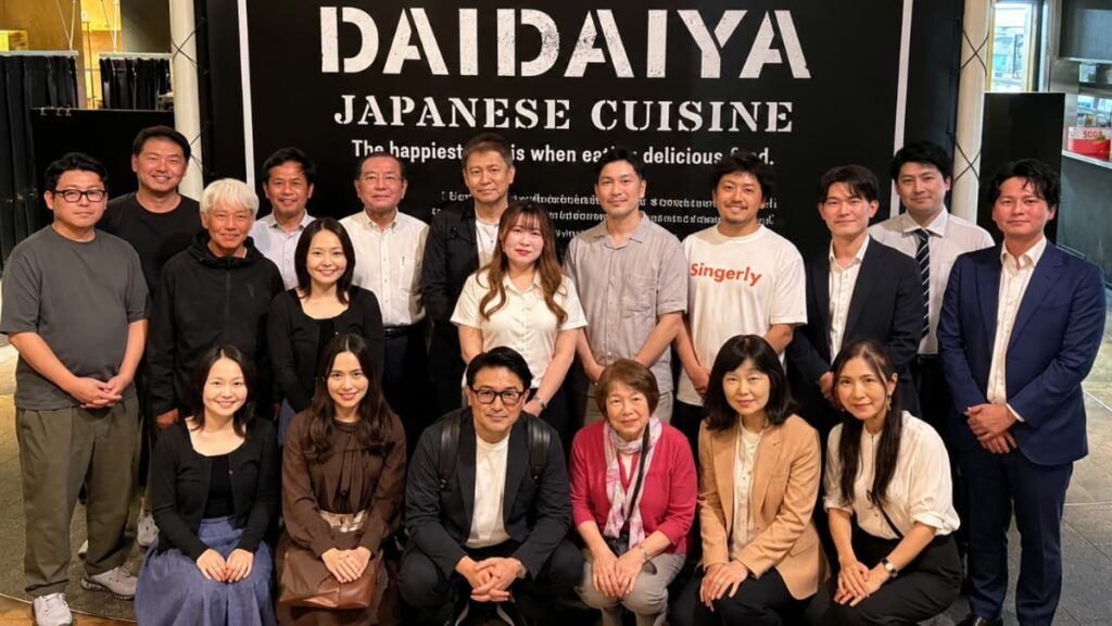 横浜異業種交流会「第1回 愛媛県人会 異業種交流会 IN 横浜」開催報告。2026年9月25日、横浜・みなとみらいの橙家（DAIDAIYA）の看板前で撮影した、参加者約20名の集合写真。